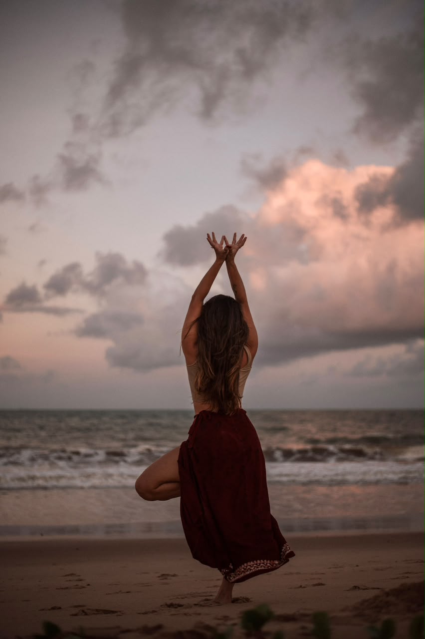 Postura da árvore de costas para o mar ao pôr do sol
